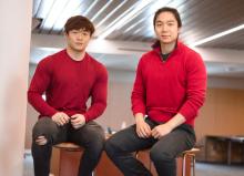 Two young Asian men wearing read sweaters and black pants. (Danny on the left and Michael on the right)