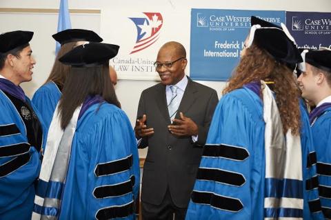 Alum Mohamed Chambas and students at graduation