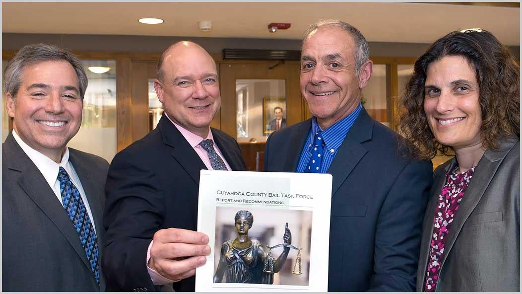 Pictured holding the final report are (left to right) Scharf, Benza, Naso, and Berg. (Not pictured: Lewis Katz)