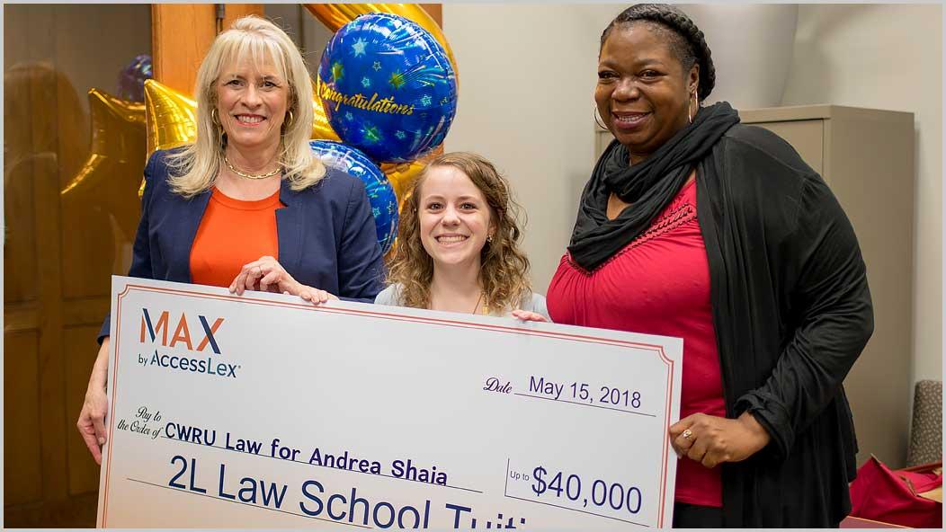 Photo of Andrea Shaia and two others holding oversized check from Access Lex, with balloons in background