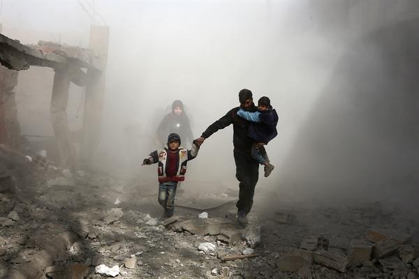 Family flees from damage outside chemical weapons production and storage facilities after missile attacks