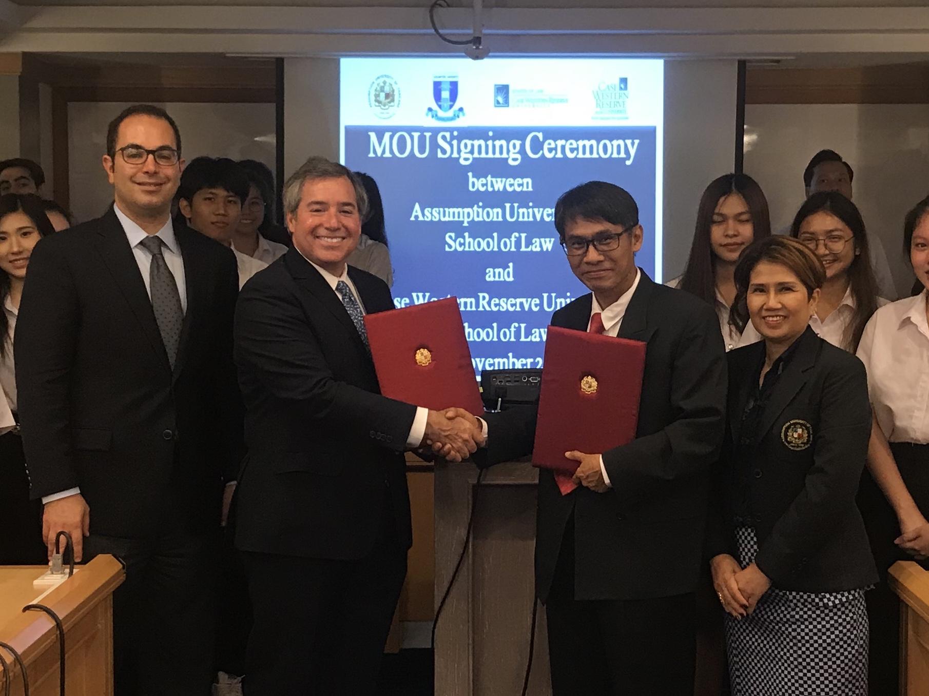 Dean Scharf and Assumption Dean Stephen Naluang signing the partnership agreement