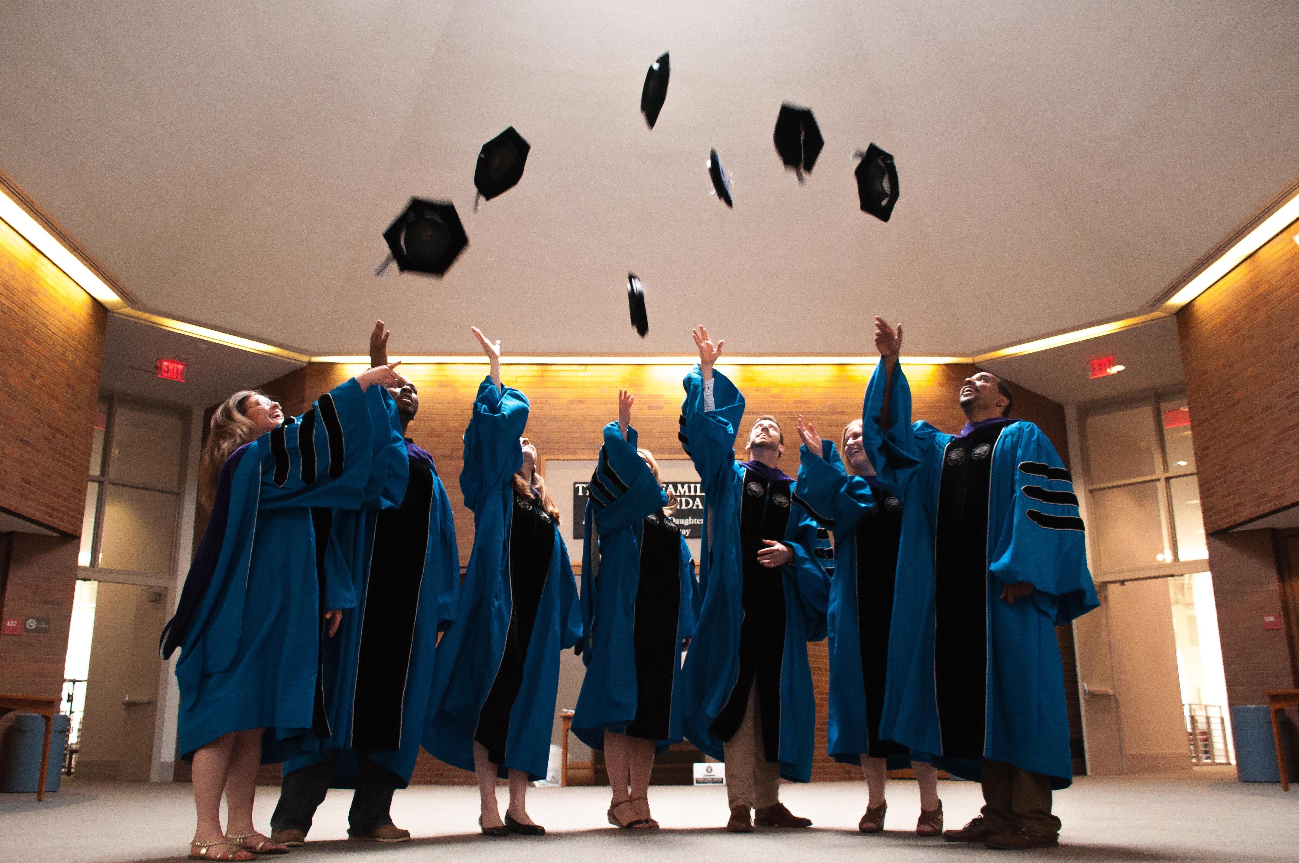 photo of graduating students throwing their caps.
