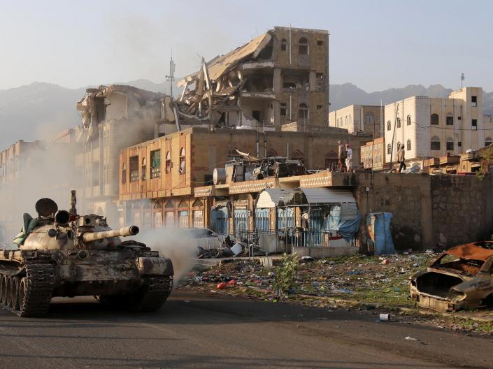 Tank driving near destroyed buildings