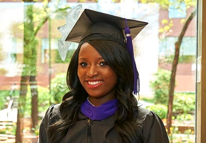 law student in black graduation robes with purple stole and tassle