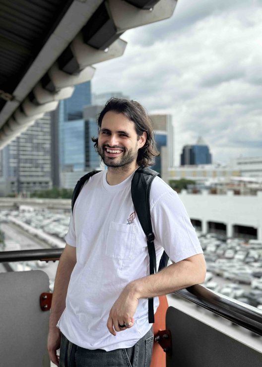 Jonathan Kronert leaning against a balcony railing and smiling