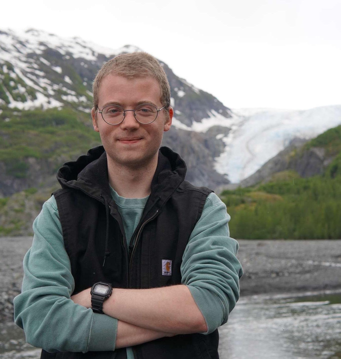 Lucas Katz standing in front of glacier 