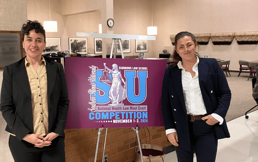 Vincent Romero and Kristen Mehalko posing by a purple sign with the details of the competition