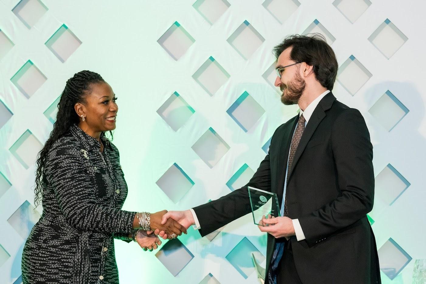 Daniel Leizerman (right) shaking hands with a Legal Aid representative as he accepts his award