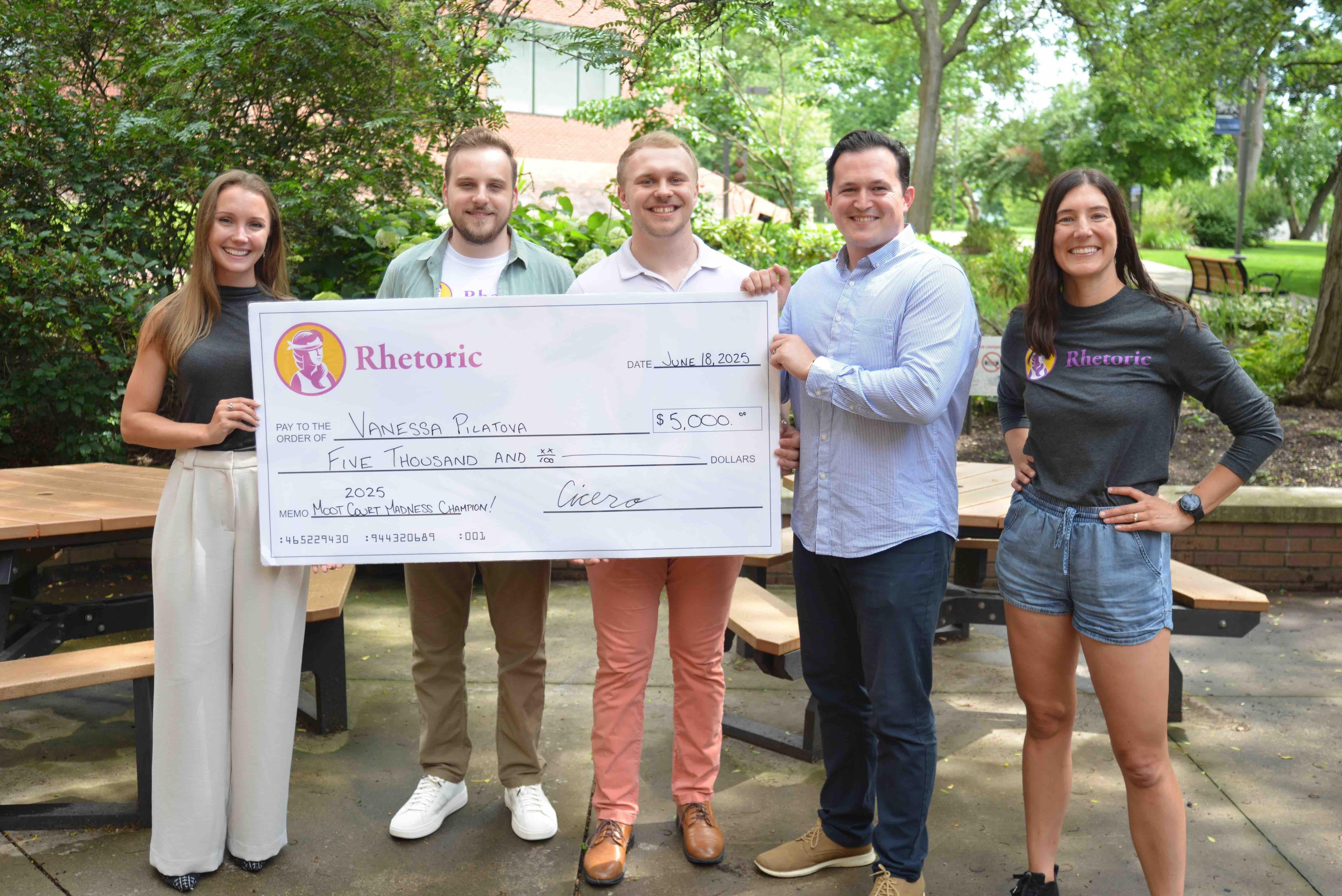 Vanessa with representatives from Rhetoric as they present her a large version of her prize (a $5,000 check)