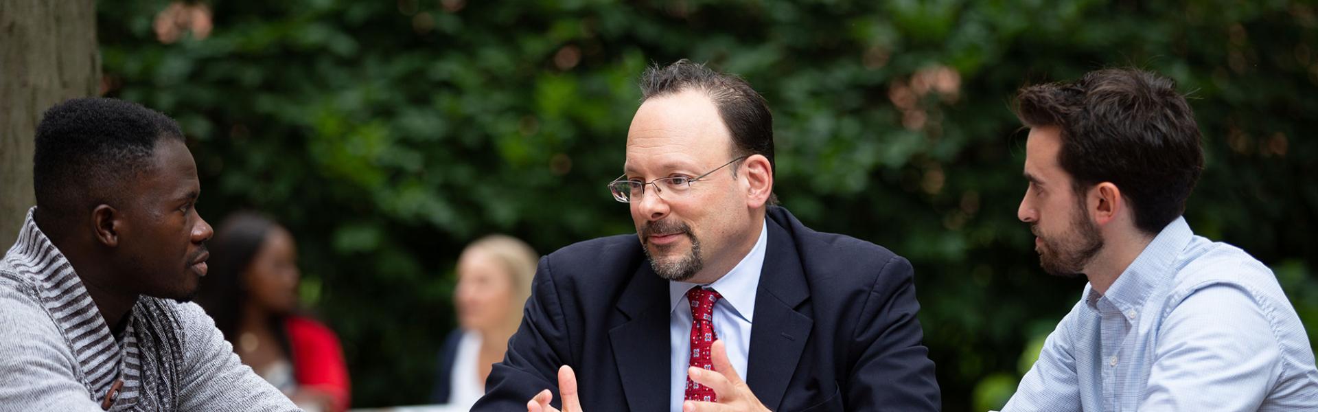 A law teacher and students talking outside of the law school