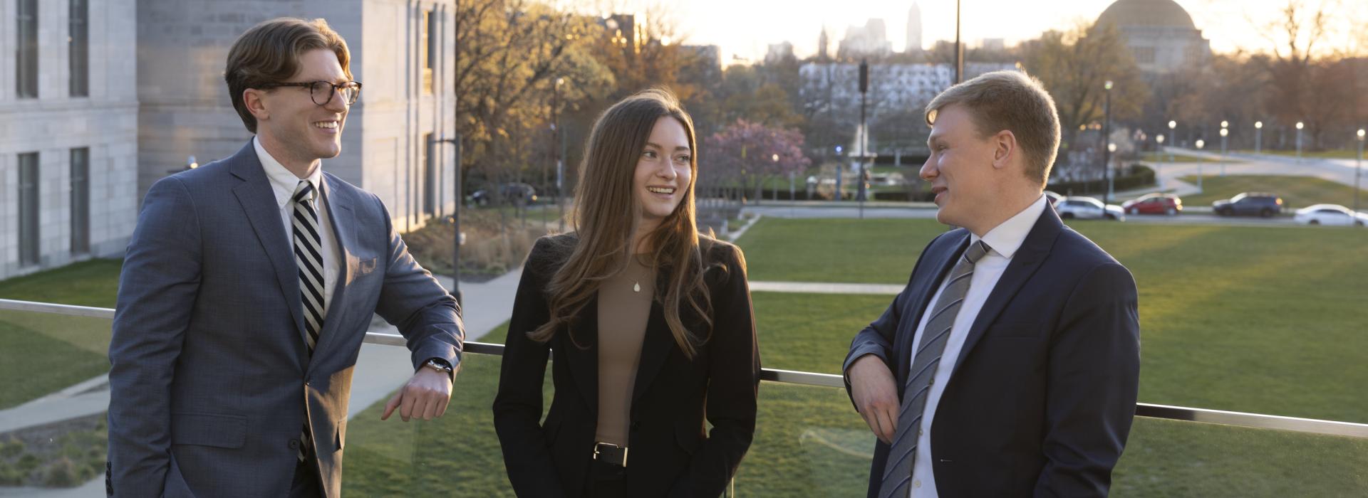 Three students standing outside on the quad