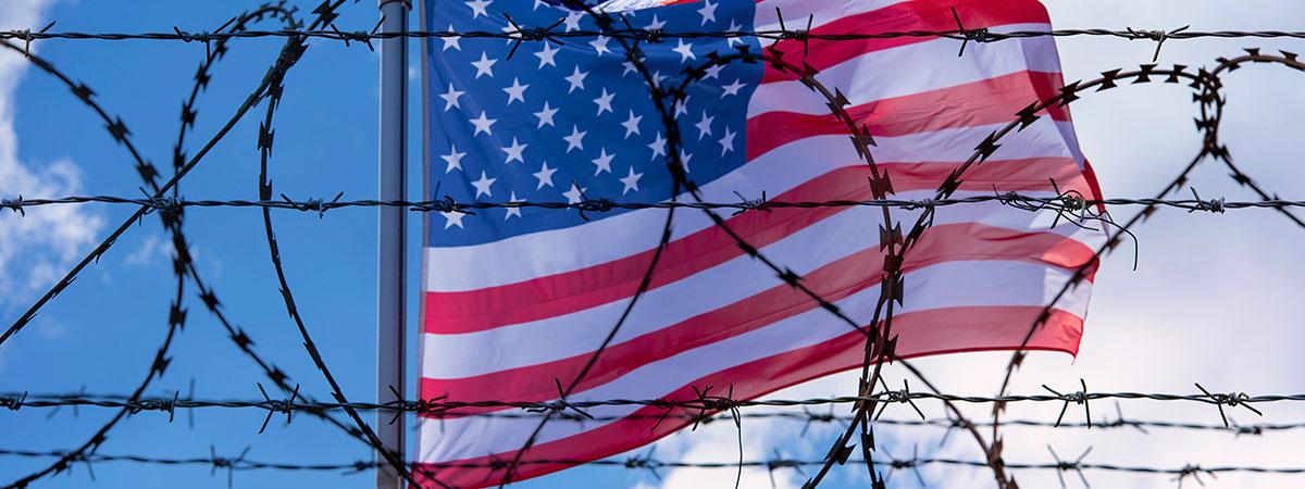 An american flag with barbed wire in front of it