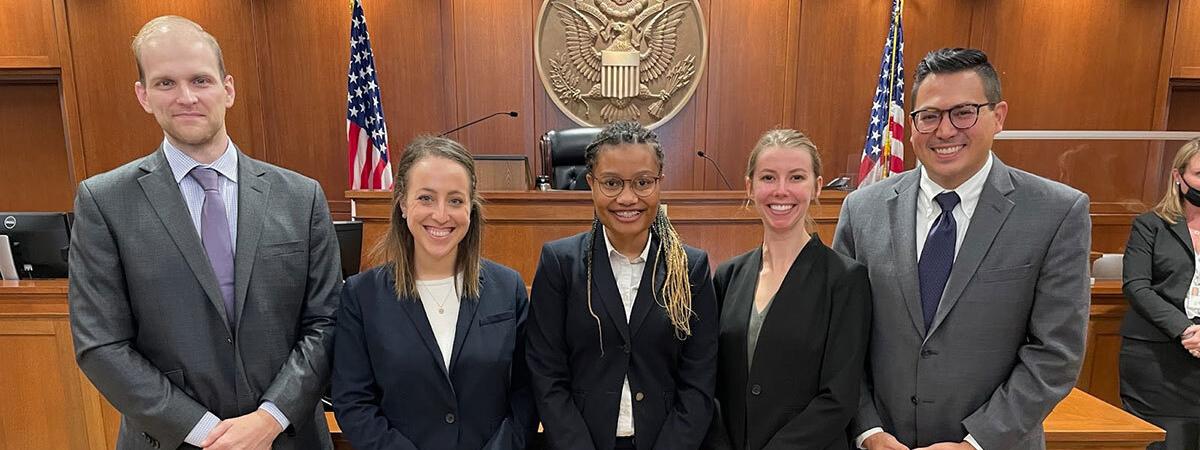 Certified Legal Interns and First Amendment Clinic faculty Standing in front for the judge's bench after a multi-day bench trial in federal district court. Pictured left to right: Certified Legal Intern Nathan Venesky (LAW ‘22), Senior Fellow Sara Coulter, Certified Legal Intern Makela Hayford (LAW ‘22), Certified Legal Intern Ginger Pinkerton (LAW ‘22), Director Andy Geronimo.