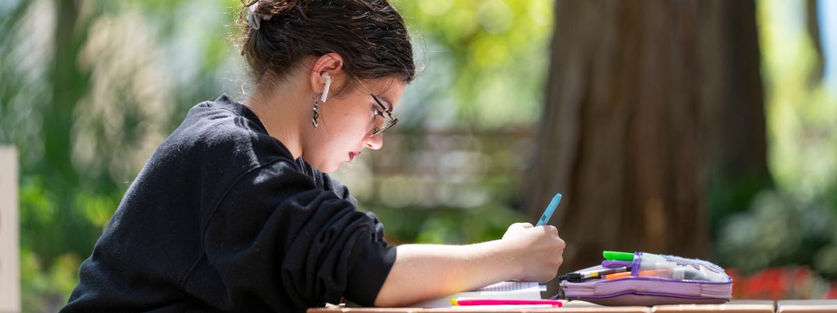 Woman studying outside at a picnic table