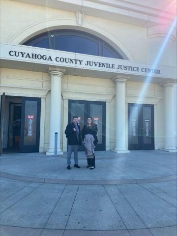 Second Chance Reentry Clinic certified legal interns Nathan Bly and Michaella Guyot-Polverini standing outside the Cuyahoga County Juvenile Justice Center building