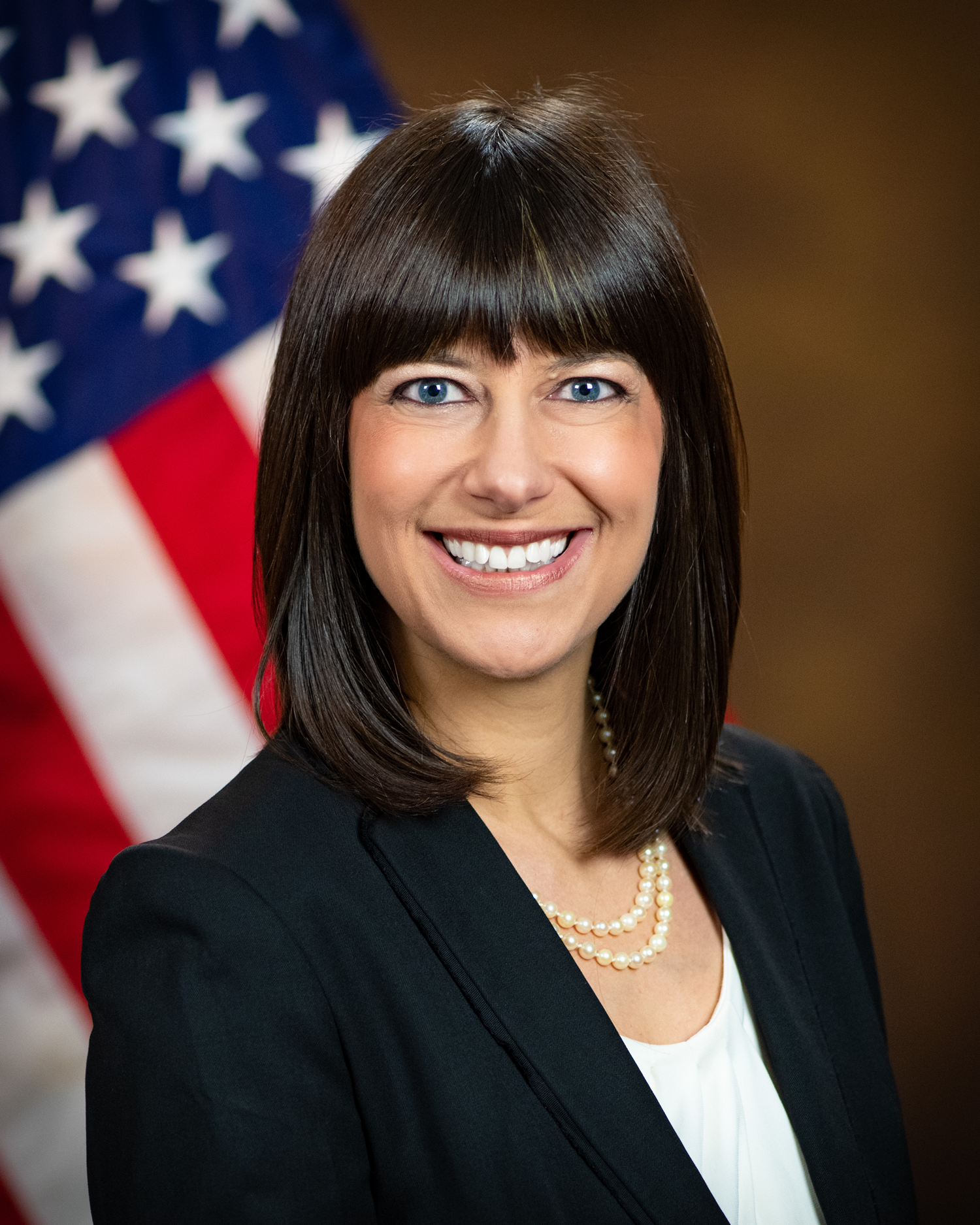 Elizabeth Barchas Prelogar headshot in front of US flag