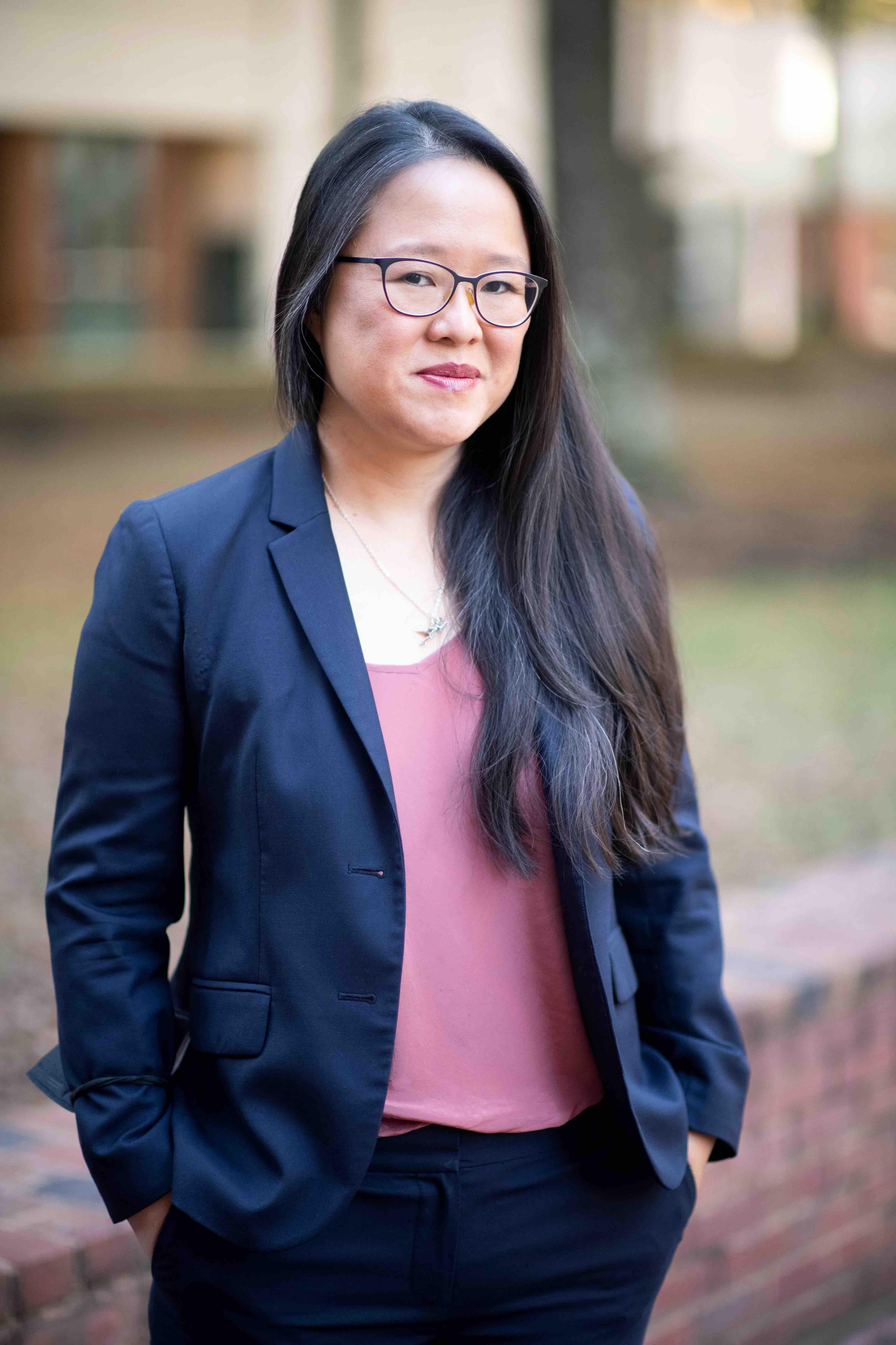 Cathy Hwang headshot, wearing a black blazer and a pink blouse