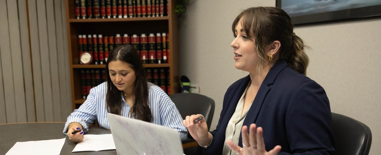 Two people sitting in front of bookcase