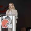 Annabelle Lincoln presenting at SportsLand Summit behind a podium with a Cleveland Browns logo on it