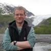 Lucas Katz standing in front of glacier 