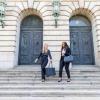 Two students walking down stairs in business attire. 