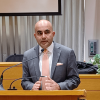 Sanjeev Bhasker behind the podium in the Moot Courtroom during his talk