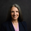 Colleen Batcheler headshot in front of dark grey background