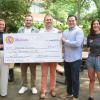 Vanessa with representatives from Rhetoric as they present her a large version of her prize (a $5,000 check)