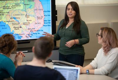 Person standing in front of group and map