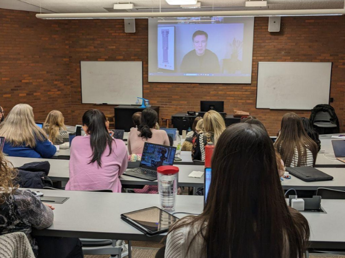 Comey being displayed on Zoom projector with students in the foreground