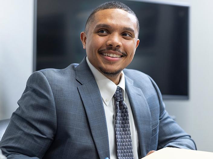 Man in tie and jacket smiling in classroom
