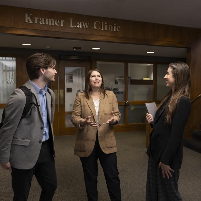 Three students standing in front of Kramer Law Clinic