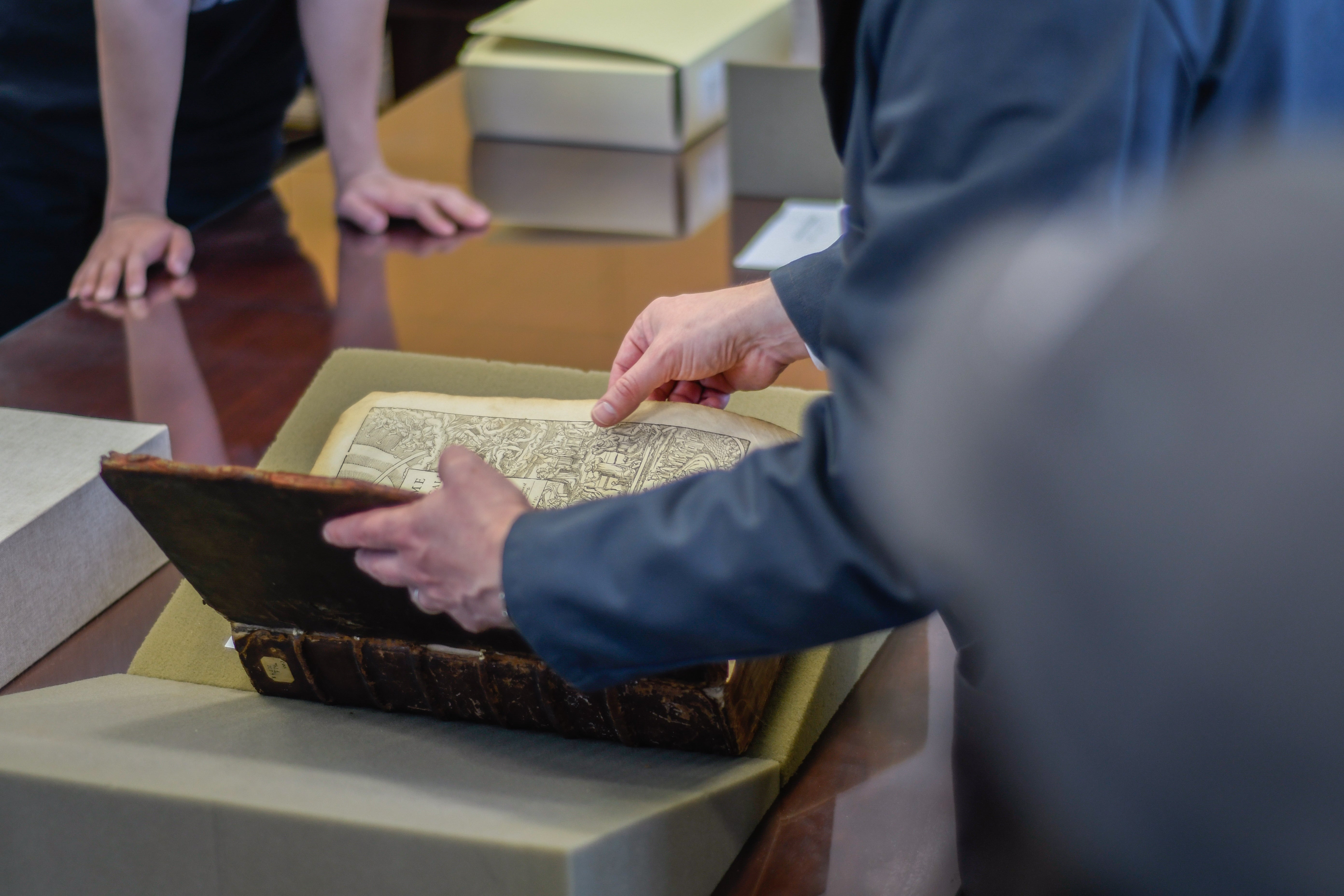 Bill Claspy opening the cover of a rare book in the Hatch Reading Room