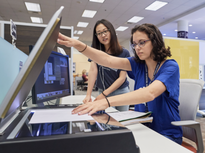 Two students using a printer at The Freedman Center for Digital Scholarship