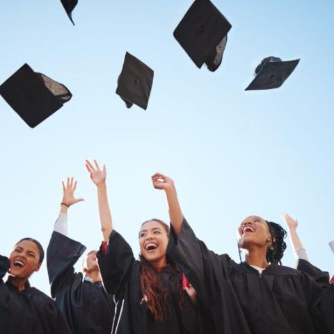 graduates throwing their caps in the air.