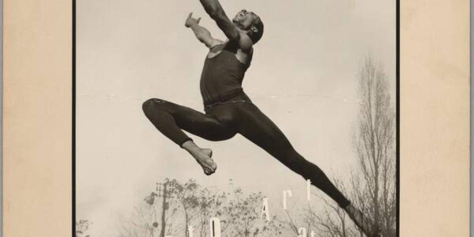 Black and white photograph of a black male in a black leotard jumping with hands forward, one leg bent, and one leg behind. Text reads "Photo Art at Karamu" 