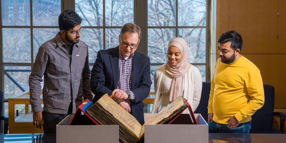 Students and KSL Special Collections staff examine a rare book