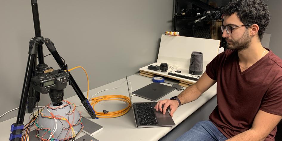 Student works on computer and preservation technology at Kelvin Smith Library.