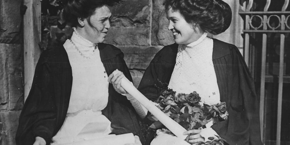 Two female graduates hold their diplomas, 1910.