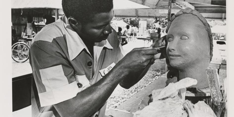 ON TOUR: Wilfred Casimir, a sculptor from Haiti, works on a woman's head at the Festival of American Folklore in Washington D.C.