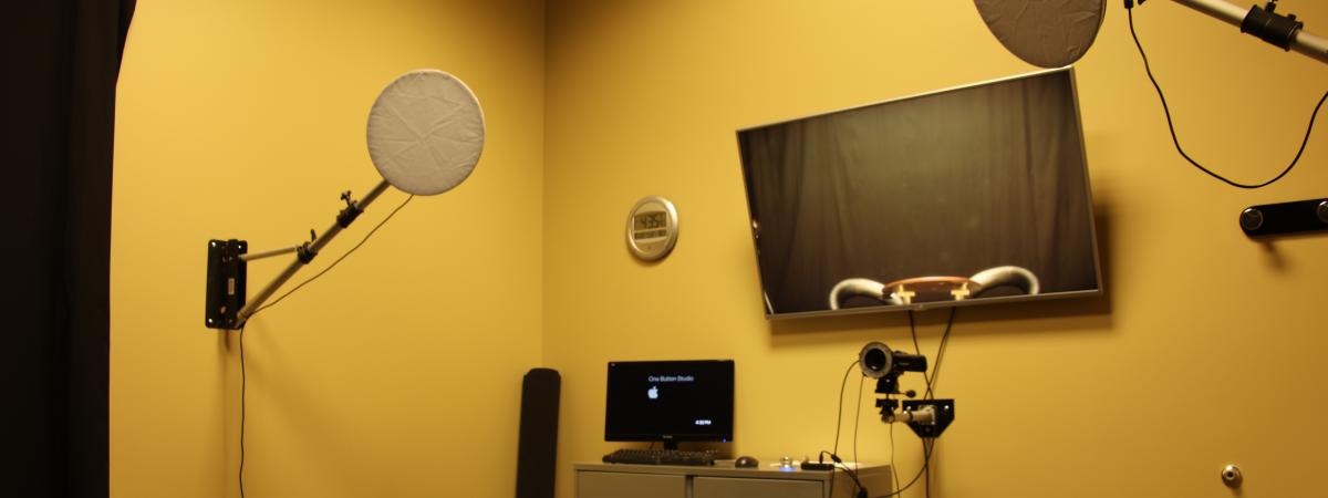 A video recording studio with lighting, screens, and a microphone.
