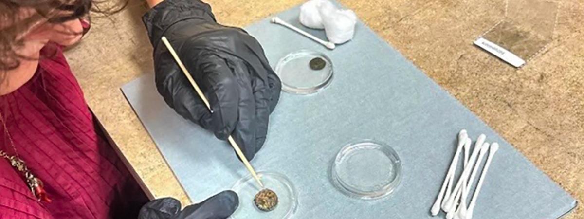 Student works on a coin conservation project at Kelvin Smith Library