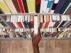 Hand taking a book off a shelf