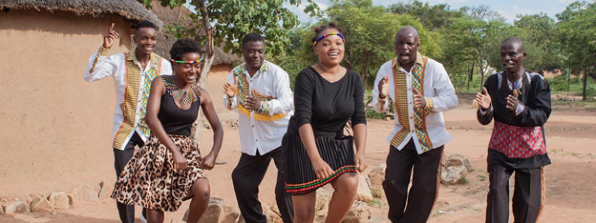 Black Umfolosi - image of dancers dancing in sandy village