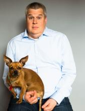 Guy sitting in a chair with a dog in his lap
