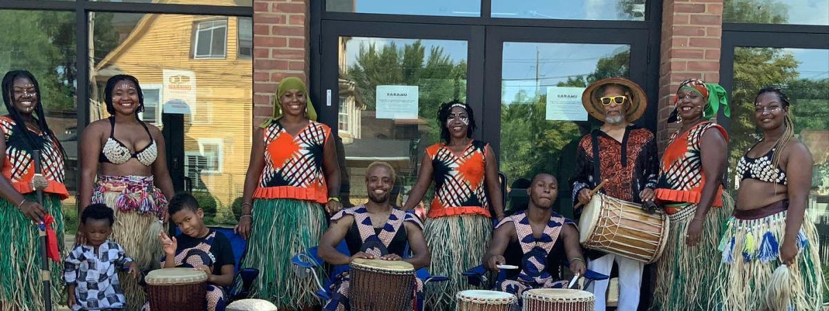DJAPO group members standing together with drums in front of them