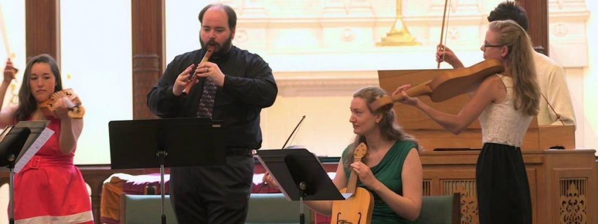 five people playing early music instruments including recorders and flutes