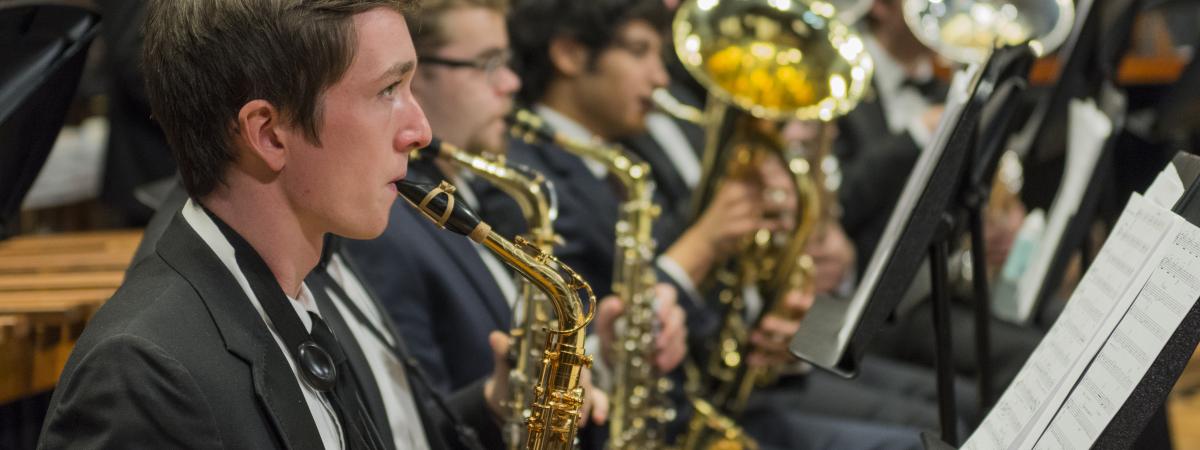 students in formal wear playing symphonic wind instruments