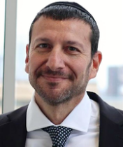Headshot of Dr. Stelzer in white dress shirt and black tie and jacket